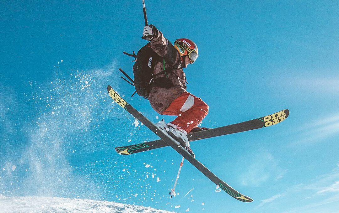 A close-up of a man doing some ski-boarding tricks on a snowy mountain slope.